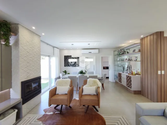 Sala de estar e jantar moderna com luz natural e lareira.