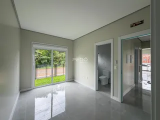 Interior de uma sala com porta de vidro abrindo para o jardim.