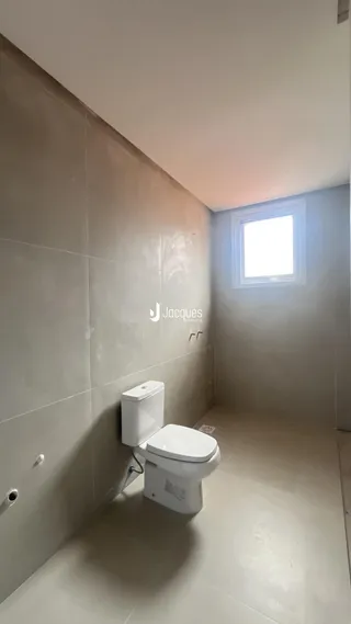Foto de um banheiro com paredes revestidas de cerâmica e um vaso sanitário branco.