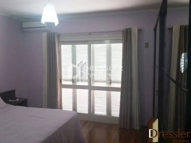 Quarto com janela e cortinas brancas.