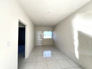 Corredor interno de uma residência com piso de cerâmica clara.