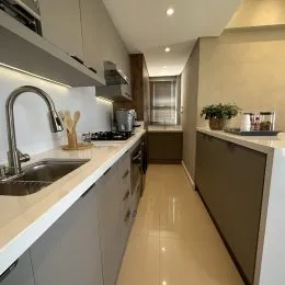 Cozinha moderna com armários brancos e bancada clara.
