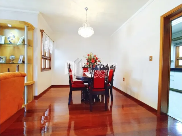 Sala de estar com piso de madeira polida e paredes brancas.