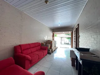 Sala com paredes de tijolo branco e piso de cerâmica.