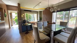 Sala de estar com piso de madeira e grandes janelas.