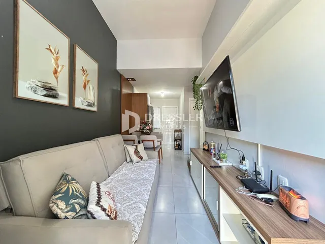 Sala de estar com sofá e decoração de parede em um apartamento.