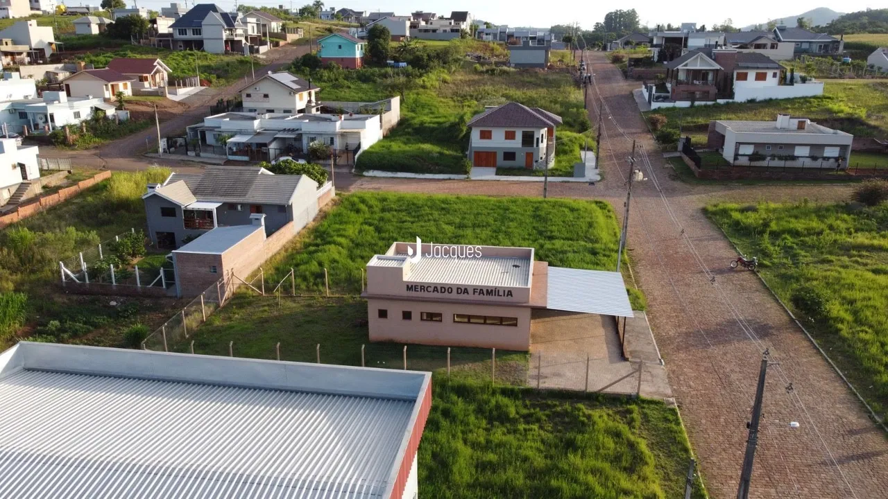 Vista aérea de uma propriedade com estruturas e área verde no entorno.