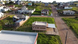 Vista aérea de uma propriedade com estruturas e área verde no entorno.