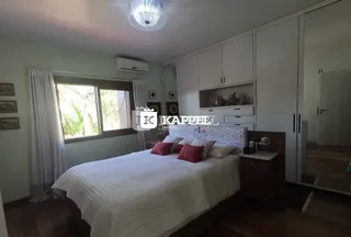Quarto com cama grande e armários brancos em um imóvel.