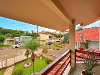 Vista da fachada de uma residência em Lajeado, Brasil, com jardim e área externa.