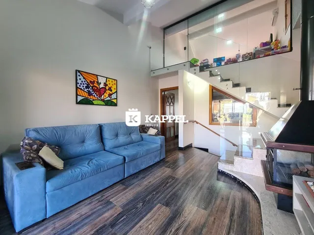 Sala de estar com sofá azul e piso de madeira em um apartamento.
