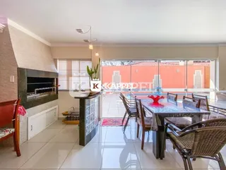 Sala de jantar com mesa e lareira em ambiente interno.