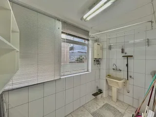 Foto de um banheiro com revestimento cerâmico e janela.