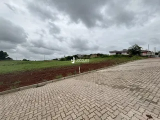 A paisagem externa da propriedade mostra um campo aberto e uma área pavimentada.