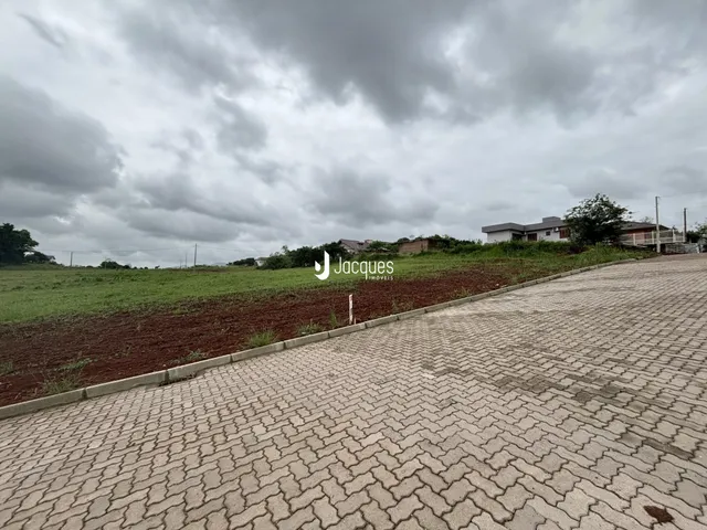 A paisagem externa da propriedade mostra um campo aberto e uma área pavimentada.