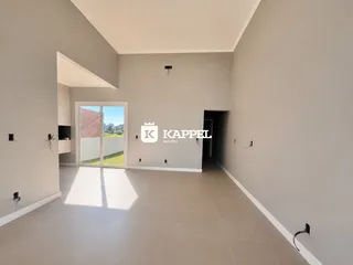 Hall de entrada com piso claro e porta de vidro que dá acesso ao exterior.