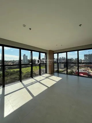 Vista ampla de uma sala com grandes janelas que se abrem para o exterior.