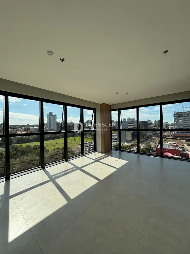 Vista ampla de uma sala com grandes janelas que se abrem para o exterior.