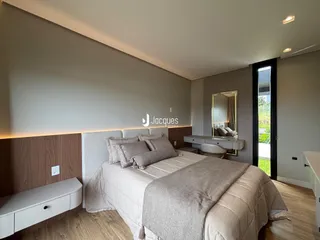 Quarto moderno com cabeceira de madeira e piso de madeira.