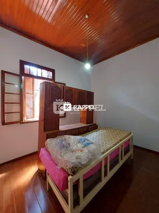 Quarto com cama de madeira e painéis de madeira na parede.