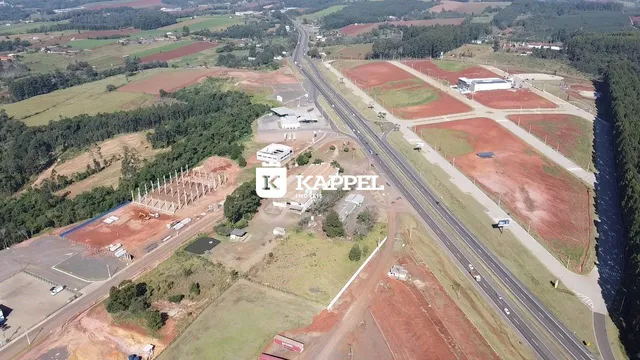 Vista aérea mostrando uma área de terra com campos e infraestrutura rodoviária.