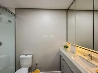 Foto de um banheiro moderno com box de vidro e bancada clara.