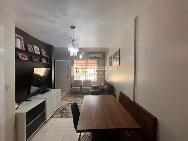 Ambiente interno de uma sala com mesa de jantar e decoração.