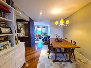 Sala de estar com piso de madeira e mesa de jantar de madeira.