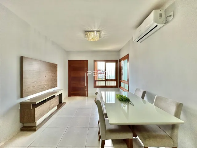 Ambiente interno de uma sala com mesa de jantar e painel de madeira.