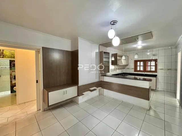 Cozinha com armários e piso de cerâmica branca.