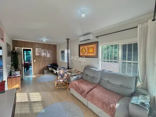 Sala de estar com sofá e piso de madeira em um imóvel no Brasil.