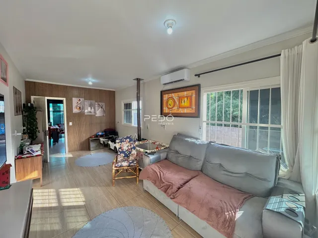 Sala de estar com sofá e piso de madeira em um imóvel no Brasil.