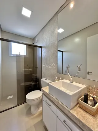 Banheiro moderno com bancada dupla e box de vidro.