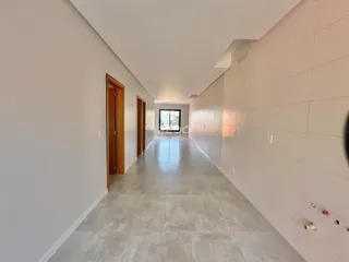 Corredor interno de uma residência com paredes brancas e piso claro.
