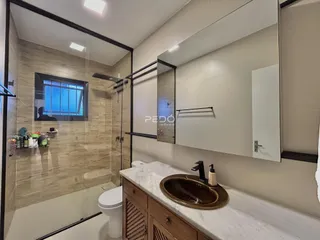 Banheiro moderno com box de vidro e piso de cerâmica.