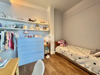 Quarto com cama e estante em um ambiente claro.
