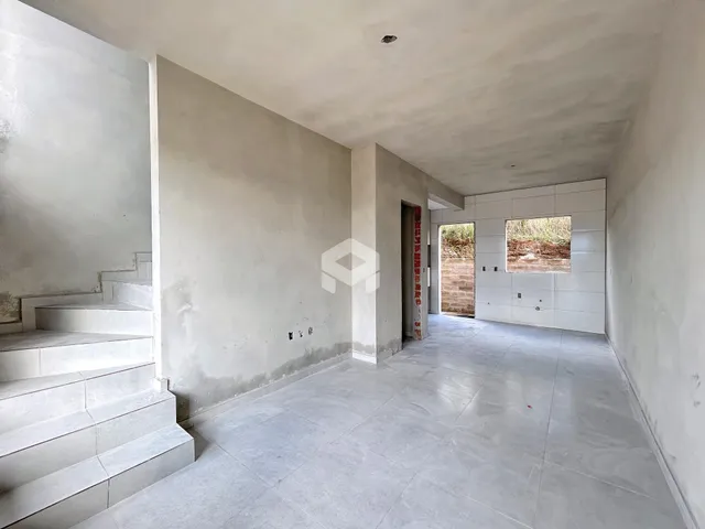 Hall de entrada com escadaria e piso de cerâmica.