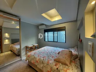 Quarto com cama e janela em ambiente interno.