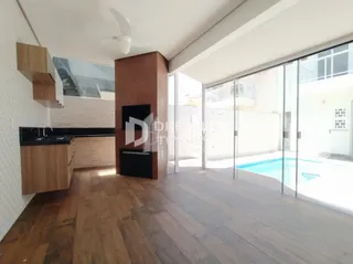 Sala de estar com piso de madeira e porta de vidro que dá para o exterior.