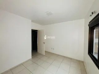 Corredor interno com piso cerâmico e paredes brancas em uma propriedade.