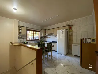 Cozinha com armários brancos e piso de cerâmica.