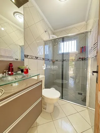 Foto de um banheiro com revestimento de azulejos brancos e box de vidro.