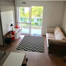 Sala de estar com portas de vidro que dão acesso a uma área externa.