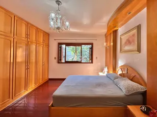 Quarto com armários em madeira e cabeceira de madeira.