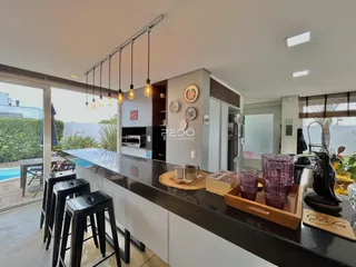 Vista da cozinha moderna com ilha e bancada escura.