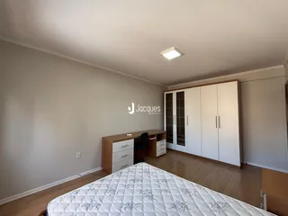 Quarto com armário e piso de madeira.