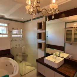 Foto de um banheiro com box de vidro e bancada de mármore.