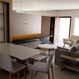 Foto de uma sala de jantar com mesa e cadeiras em um ambiente claro.