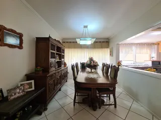 Uma sala de jantar com mesa de madeira e armários.