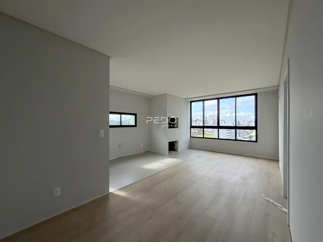 Sala de estar com piso de madeira e grande janela de vista para a cidade.